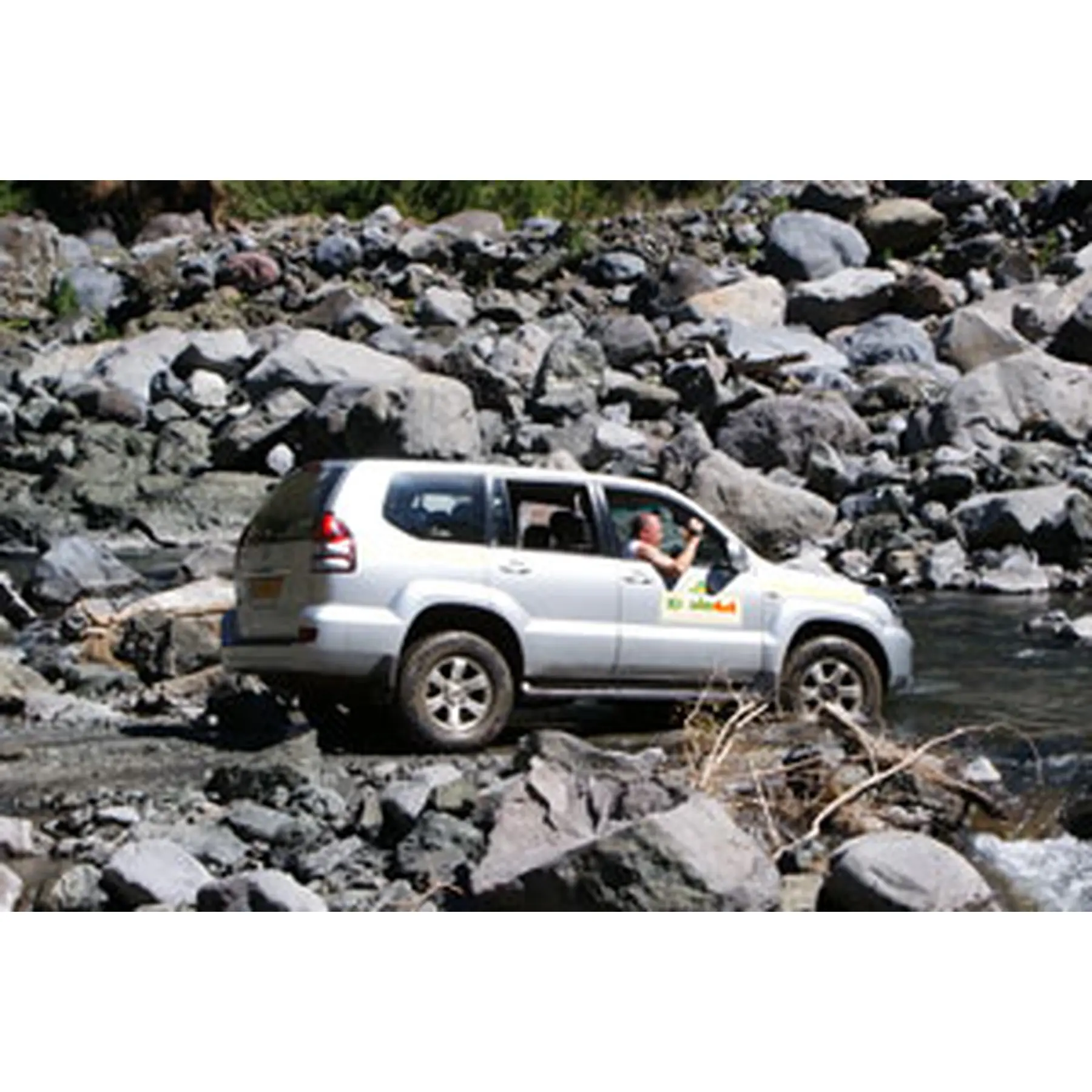 Véhicule Kréolie 4x4 traversant un passage rocheux